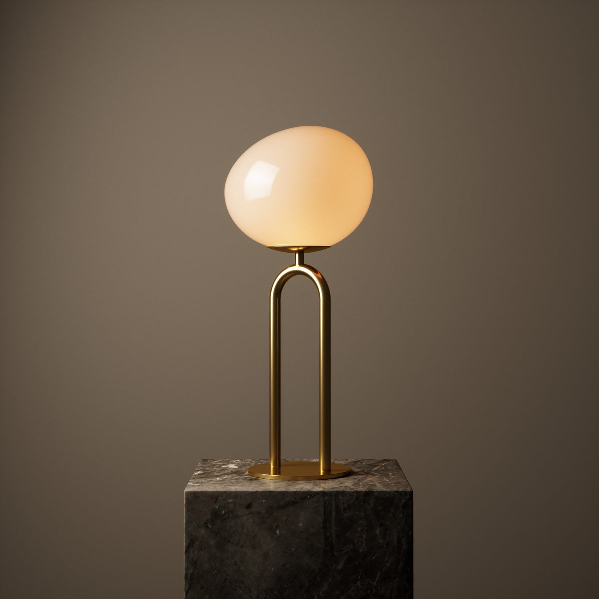 Lampe à poser allumée sur socle en marbre, fond sombre et lumière chaude.