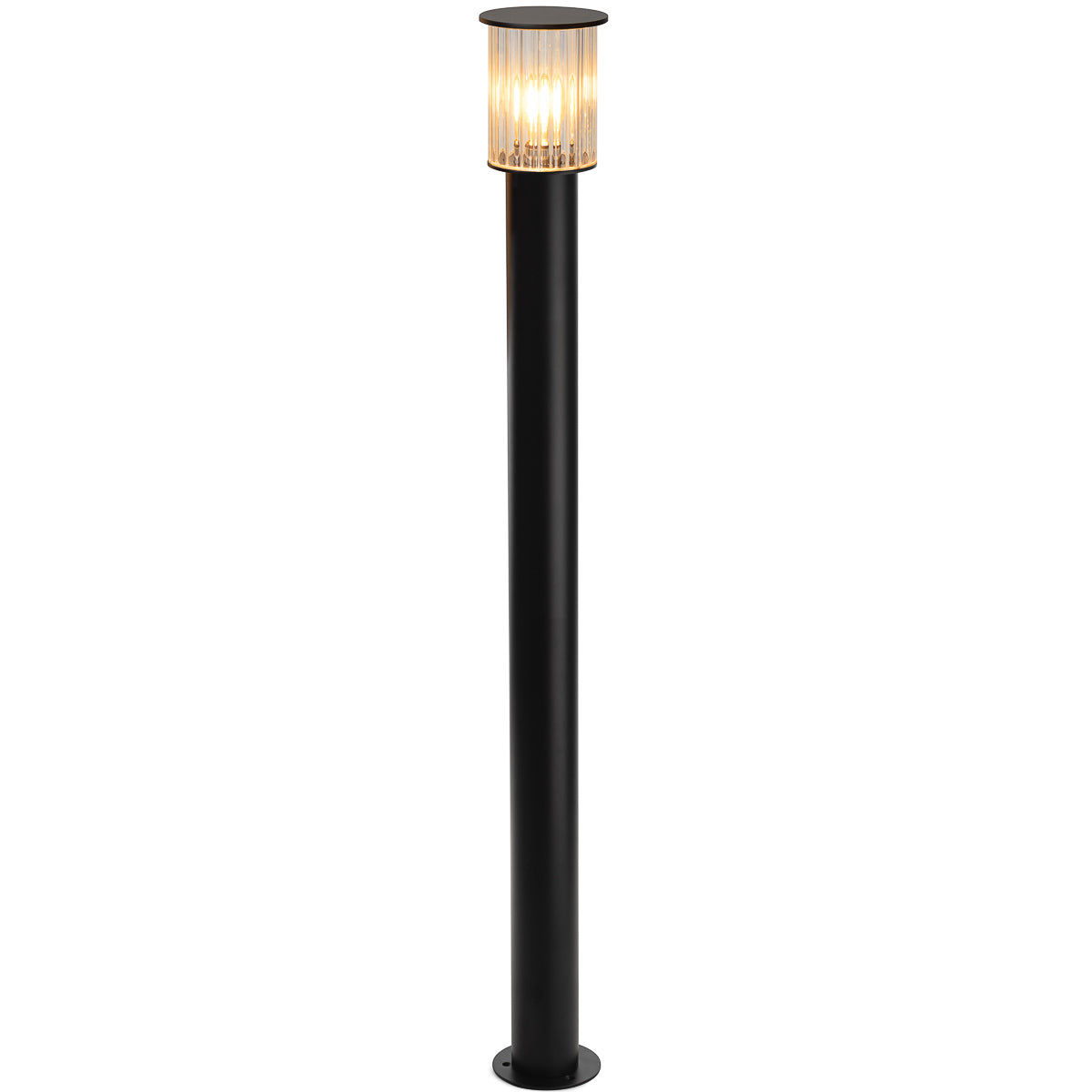 Lampadaire extérieur allumé émettant une lumière chaude à travers son diffuseur en verre rainuré.