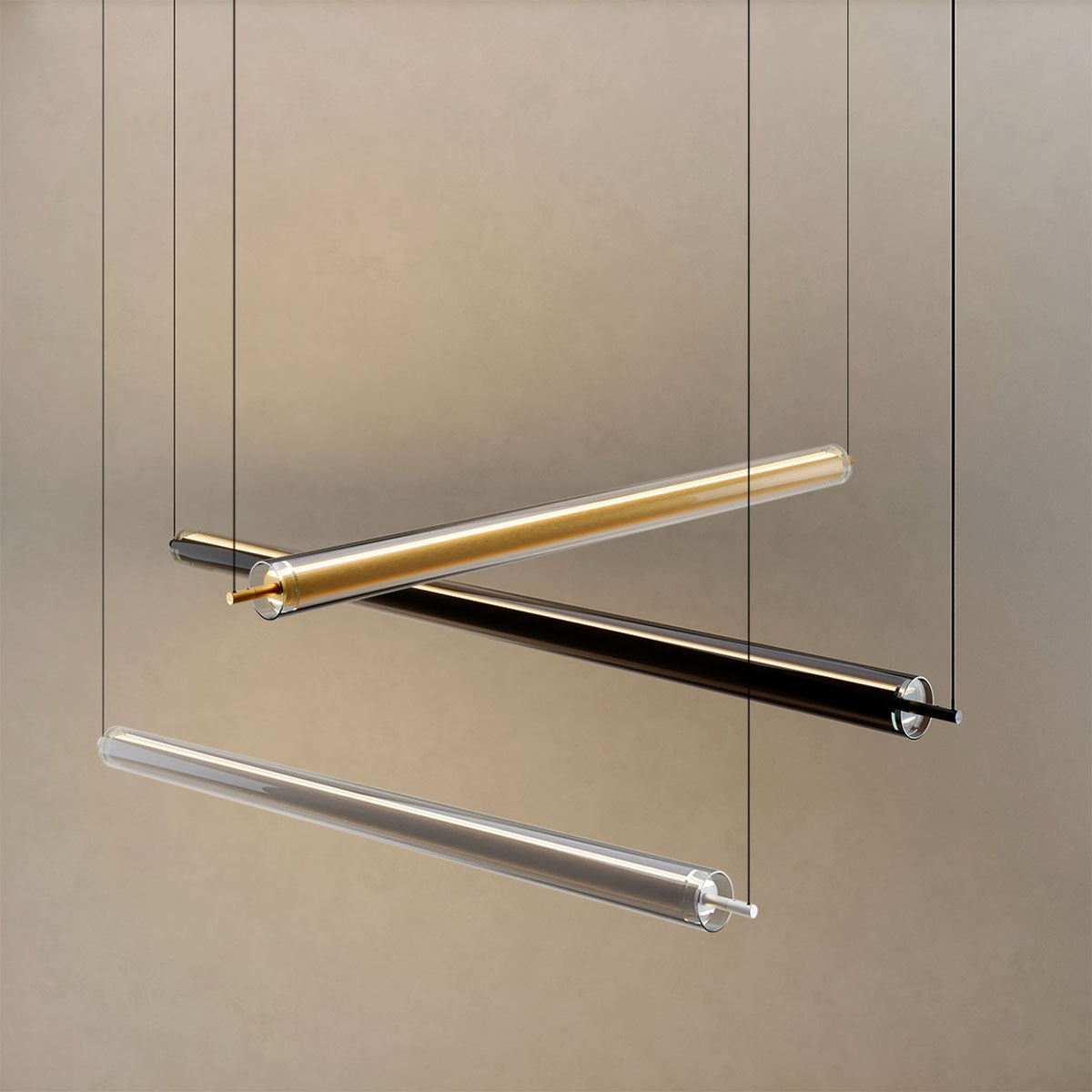 Trois tubes de finitions dorée, noire et transparente suspendus côte à côte