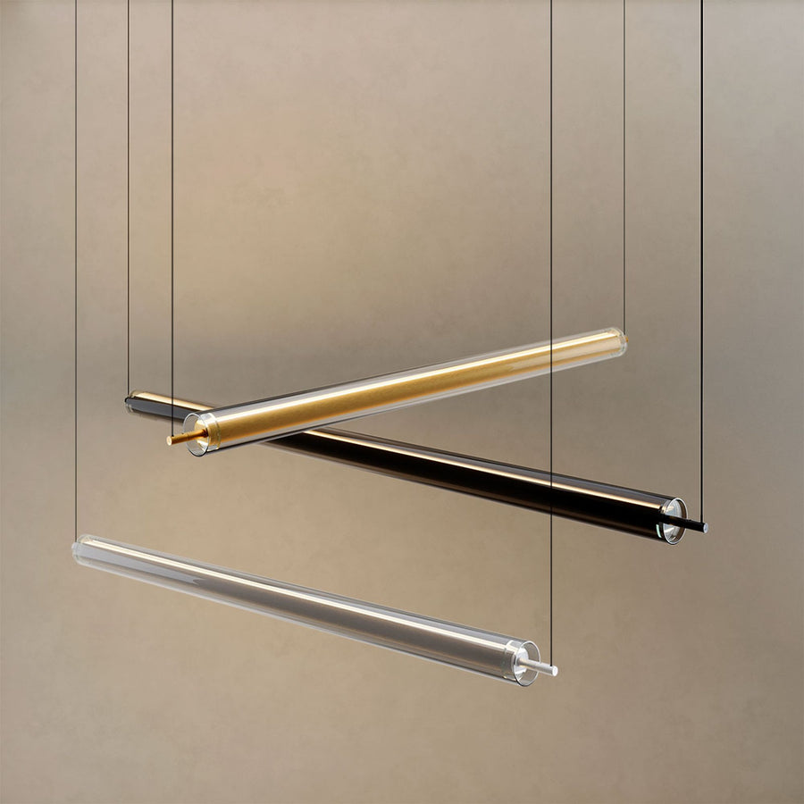 Trois tubes de finitions dorée, noire et transparente suspendus côte à côte