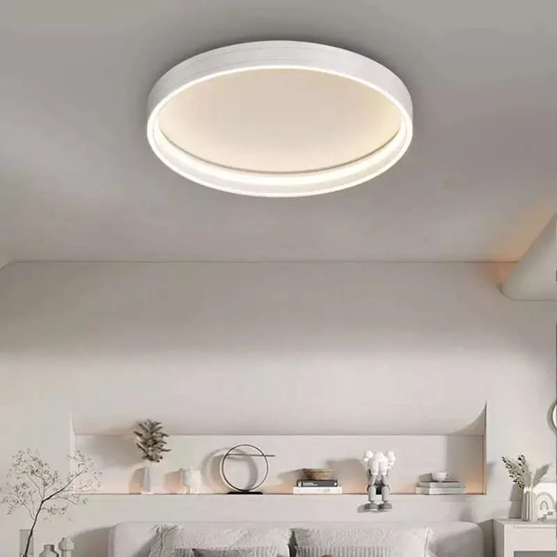 Plafonnier rond blanc, lumière chaude, au-dessus d'une étagère de décoration.