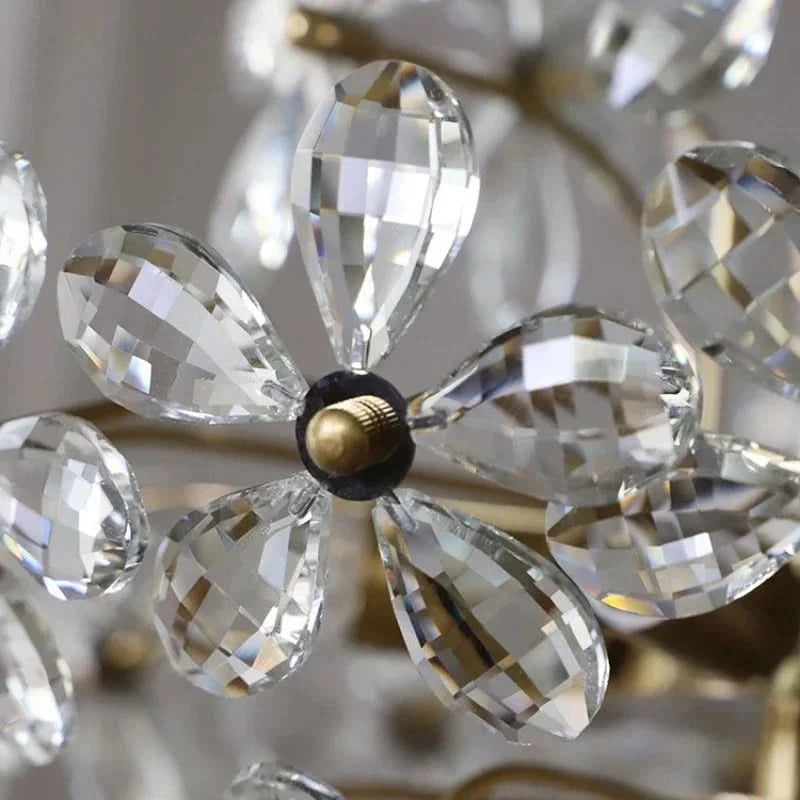 Détail d'une fleur en cristal taillé avec pétales en goutte et pastille centrale dorée.