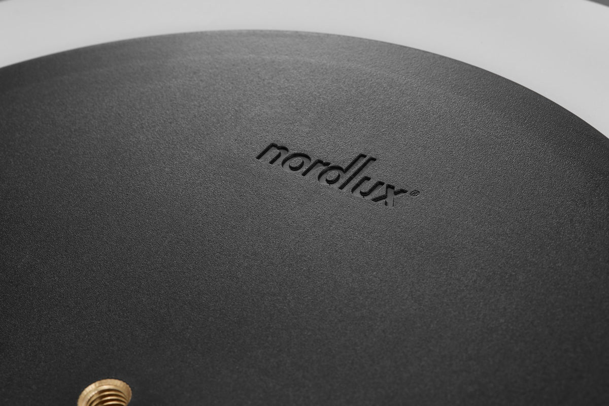 Macro d'une base noire granuleuse avec le logo de la marque embossé
