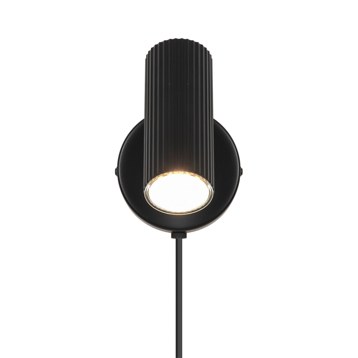 Vue frontale de l’applique noire, tête cylindrique cannelée éclairée vers le bas.