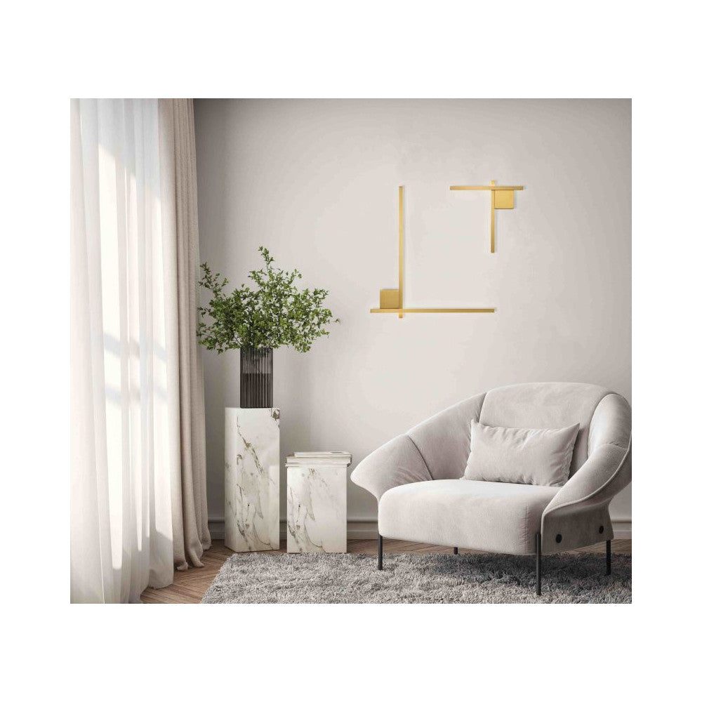Mise en ambiance salon : applique dorée au mur près d'un fauteuil et d'une plante
