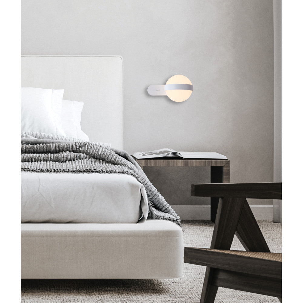 Vue de trois quarts dans une chambre claire, lampe murale suspendue près du lit