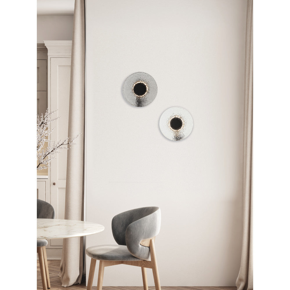 Applique ronde éclairée fixée sur un mur clair près d'une table marbre