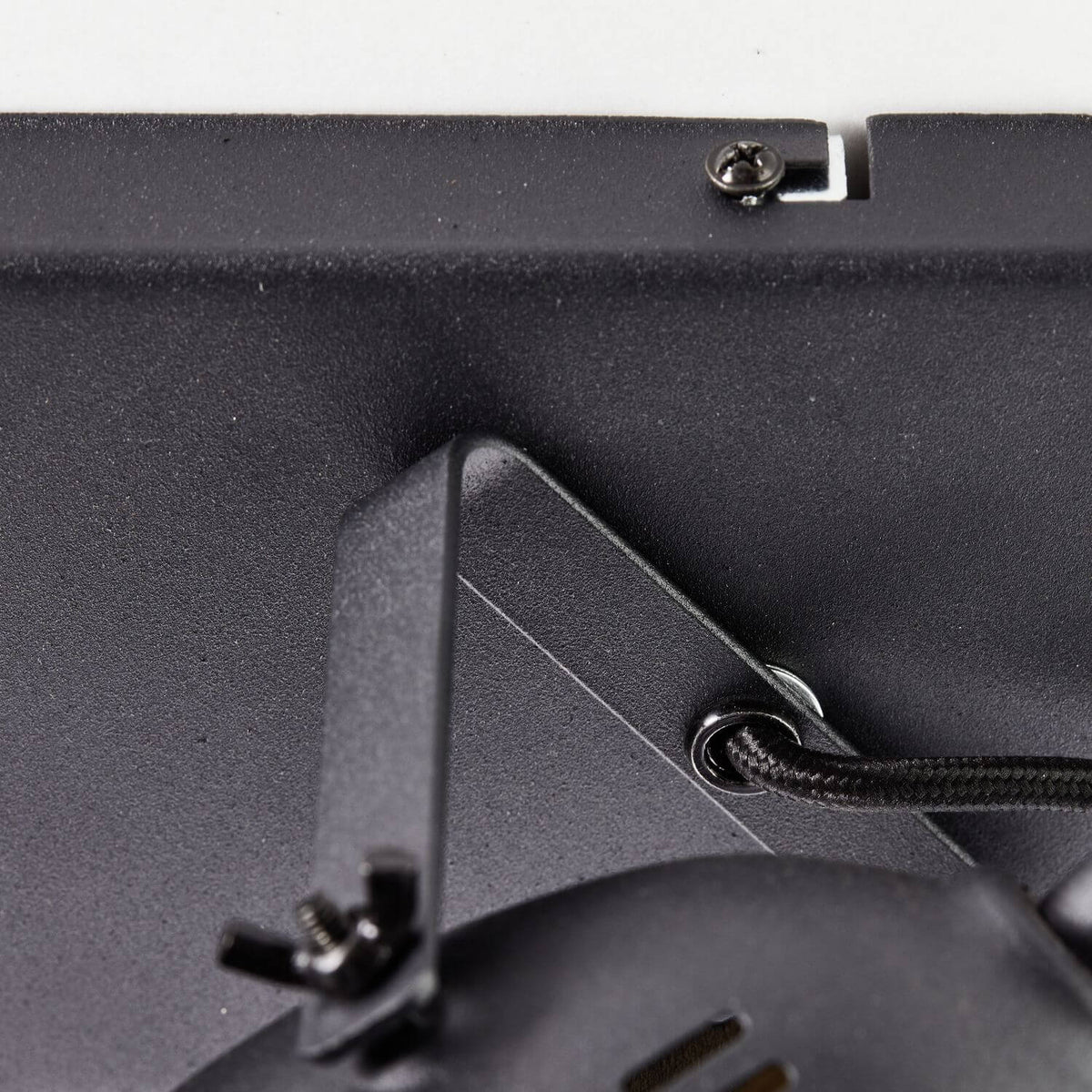 Détail de la fixation et du câble tressé noir sur le support du plafonnier