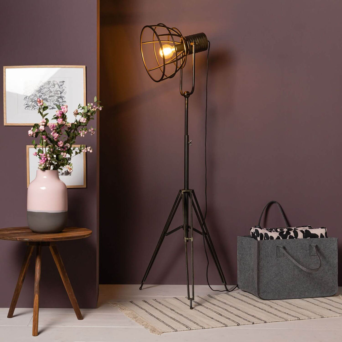 Mise en ambiance salon au mur violet, lampadaire allumé près d'une petite table