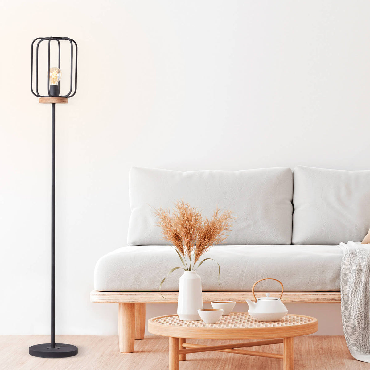 Lampadaire installé près d'un canapé blanc dans un salon lumineux et épuré