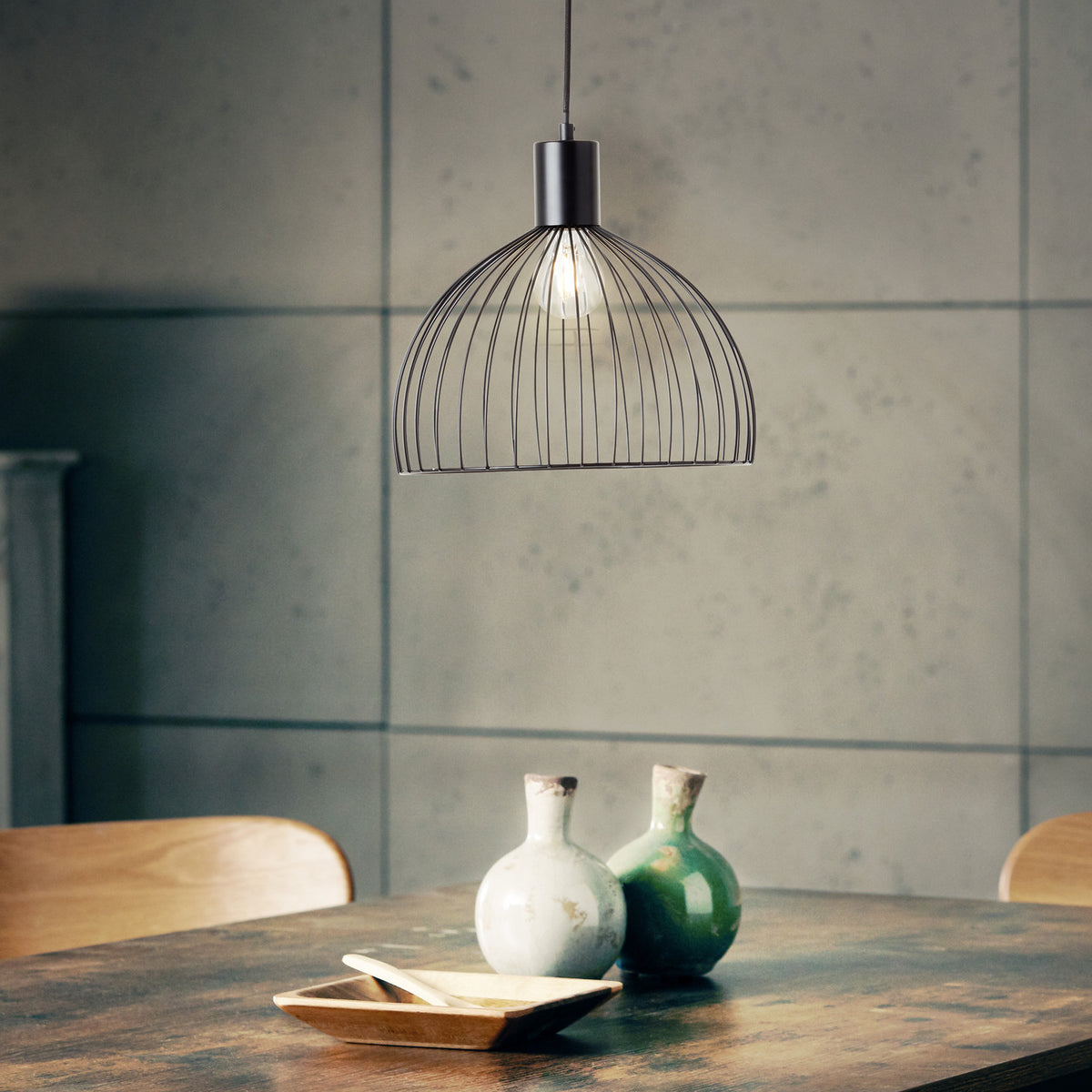 Mise en ambiance au-dessus d'une table en bois, suspension allumée dans un intérieur contemporain.