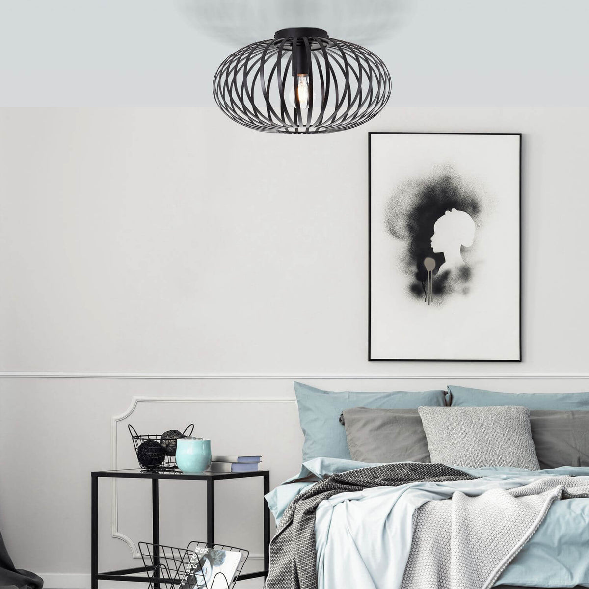Mise en ambiance dans une chambre, lit gris et bleu, affiche encadrée au mur