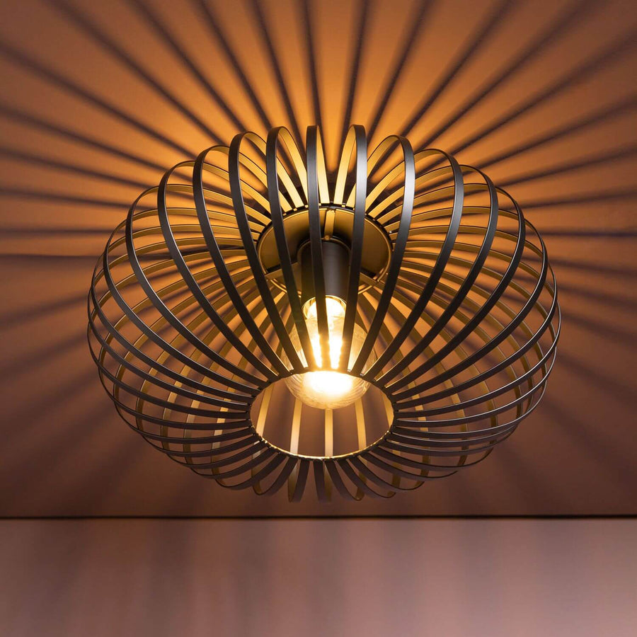 Luminaire allumé projetant des ombres rayonnantes chaudes sur le plafond