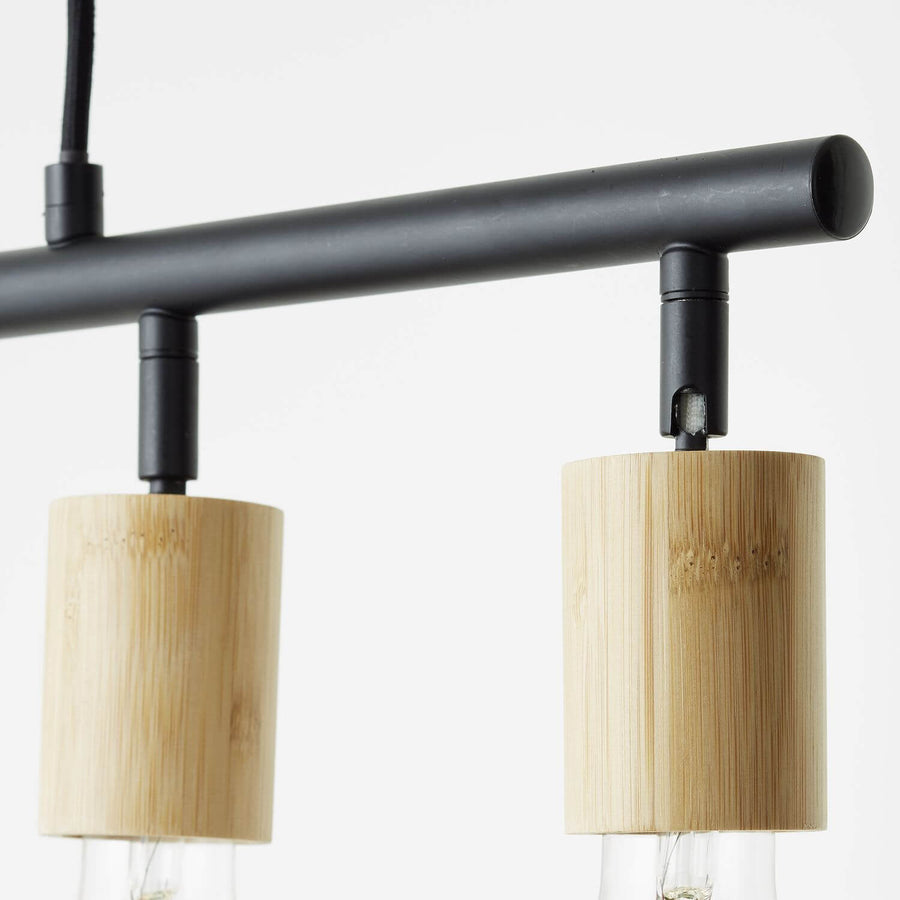 Gros plan sur deux douilles cylindriques en bambou et la barre tubulaire noire