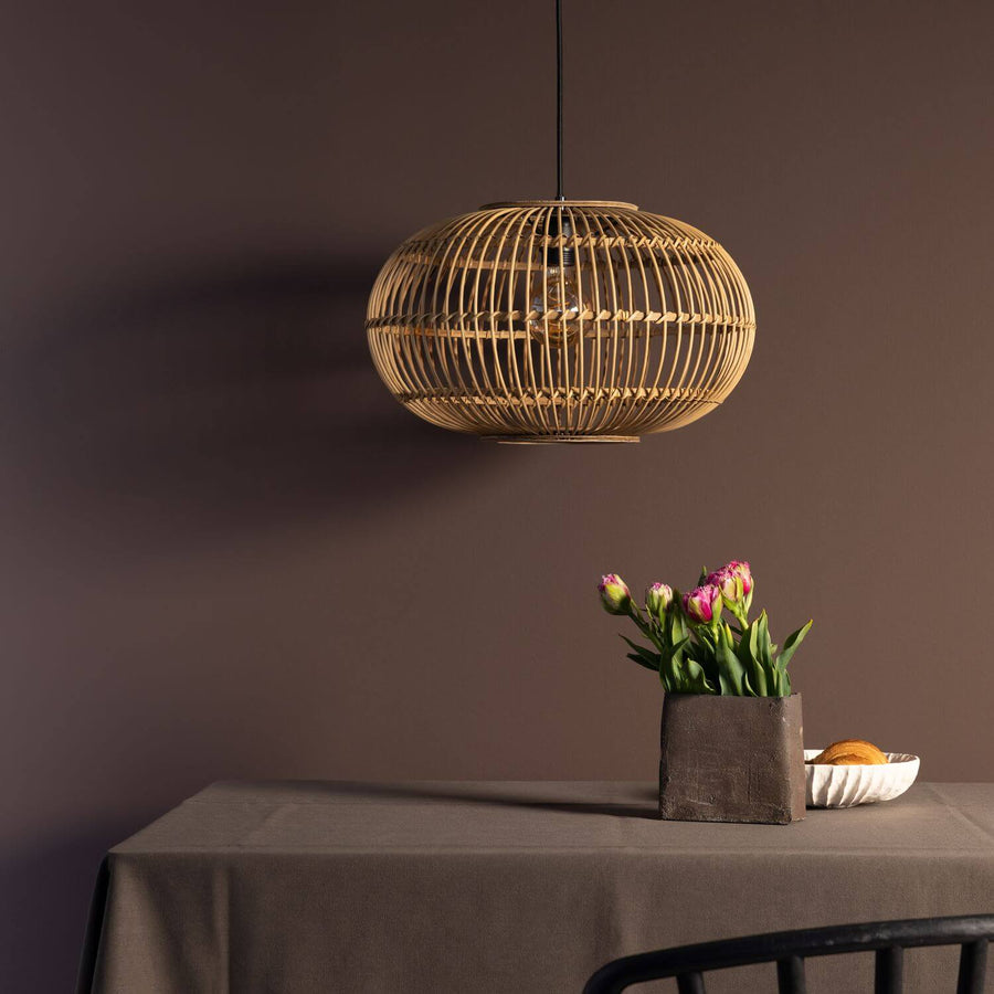Vue de trois quarts de la suspension éteinte dans un intérieur aux tons bruns.