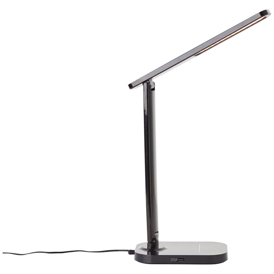 Lampe noire vue de profil avec son câble d'alimentation posé au sol.