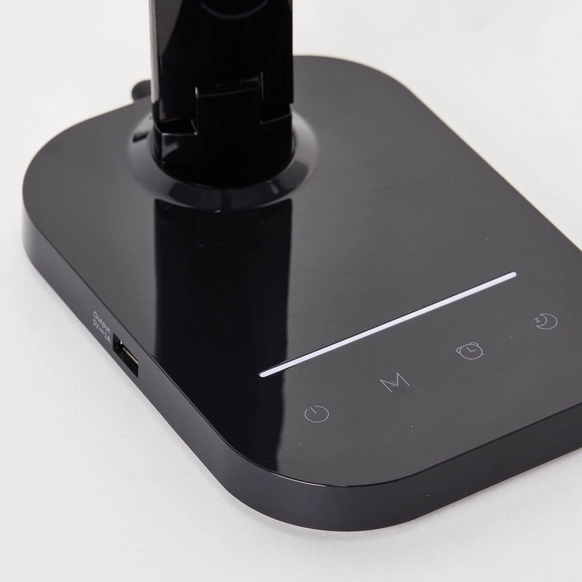 Détail de la base tactile noire avec symboles lumineux et port USB latéral.