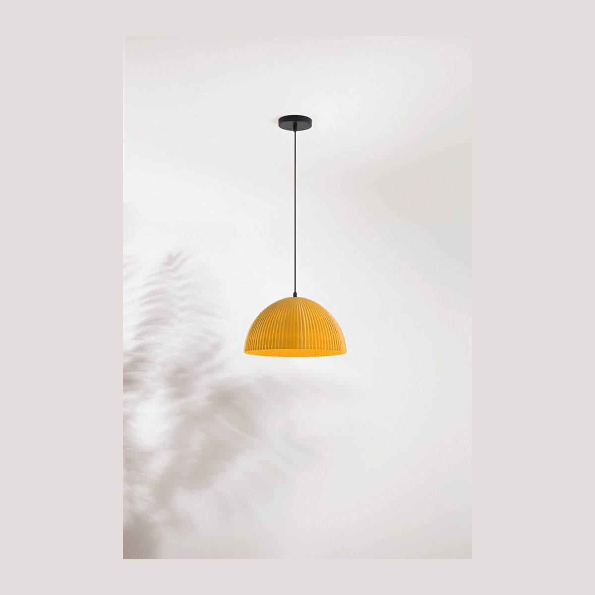 Suspension jaune à abat-jour dôme côtelé, vue de face sur fond clair