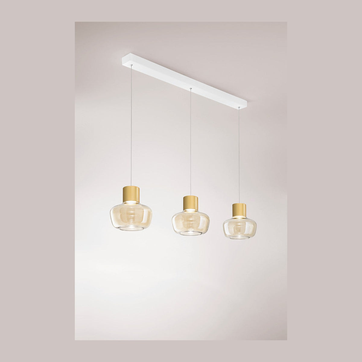 Suspension trois verres transparents dorés alignés sur barre blanche fixée au plafond