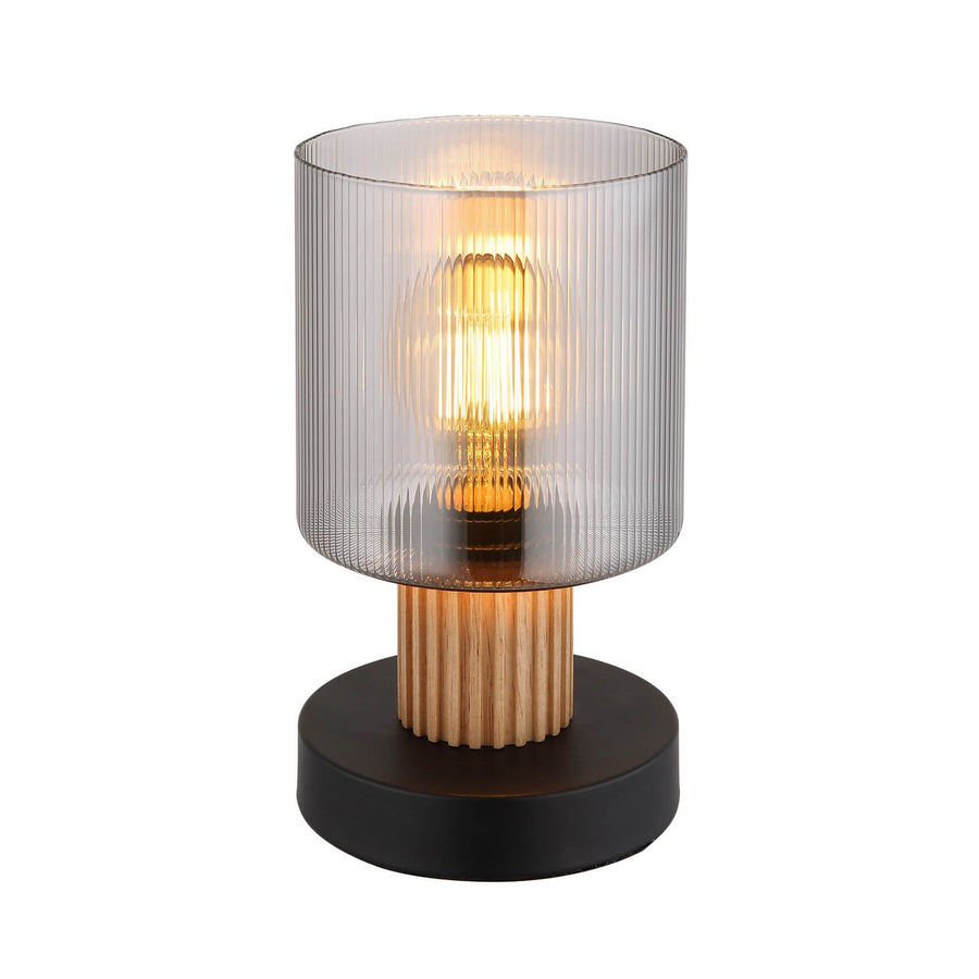 Lampe à poser noire et bois, vue de face, verre strié et ampoule allumée