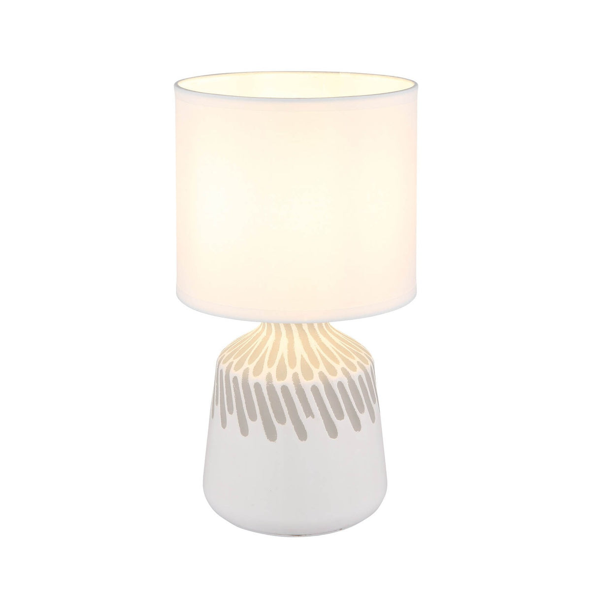 Lampe à poser blanche de face sur fond blanc, abat-jour cylindrique allumé.