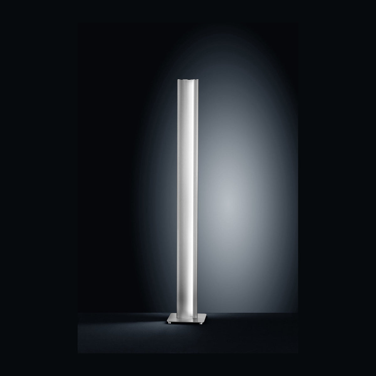 Lampadaire cylindrique en nickel sur fond noir, éclairage diffus.