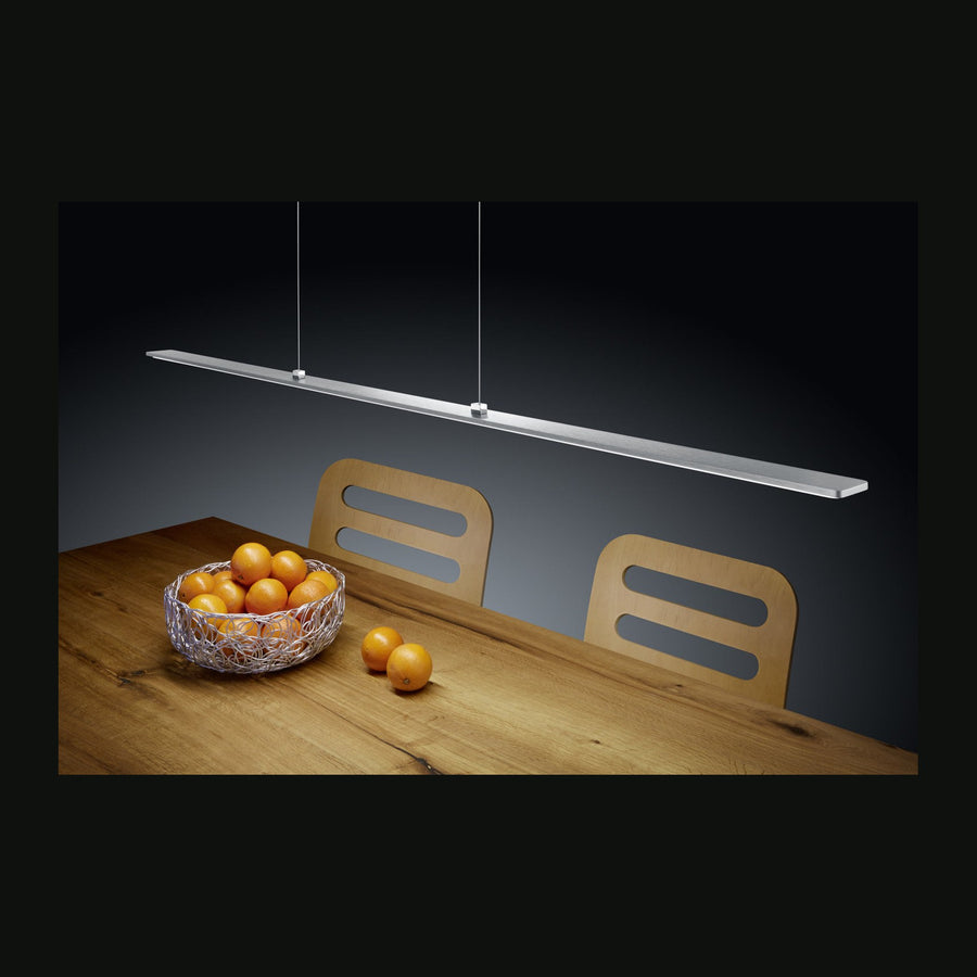 Suspension linéaire en nickel au-dessus d'une table en bois et d'oranges
