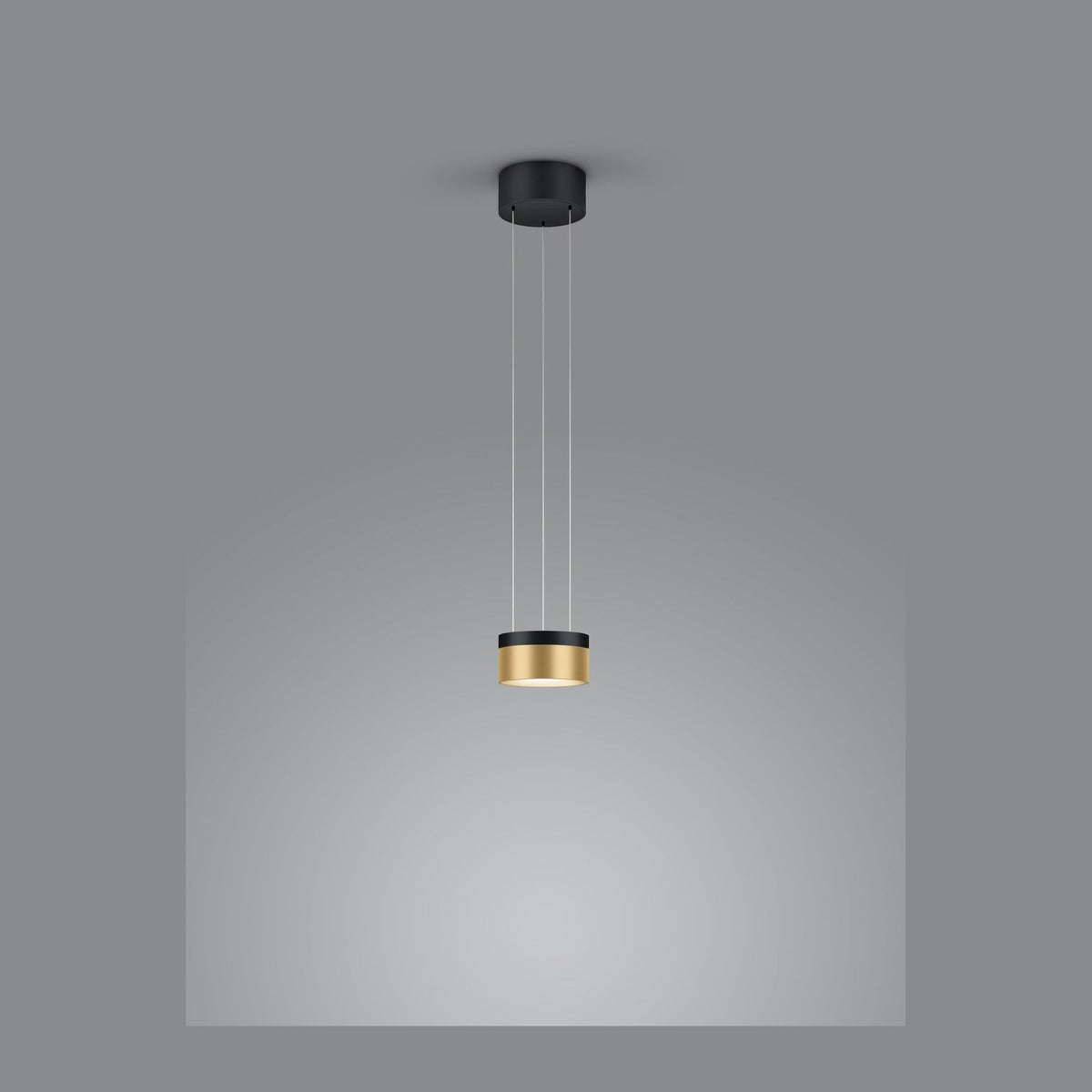 Vue de face de la suspension cylindrique noire et dorée suspendue sur fond gris.
