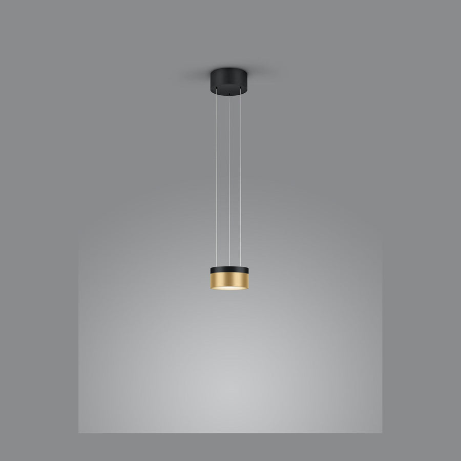 Vue de face de la suspension cylindrique noire et dorée suspendue sur fond gris.
