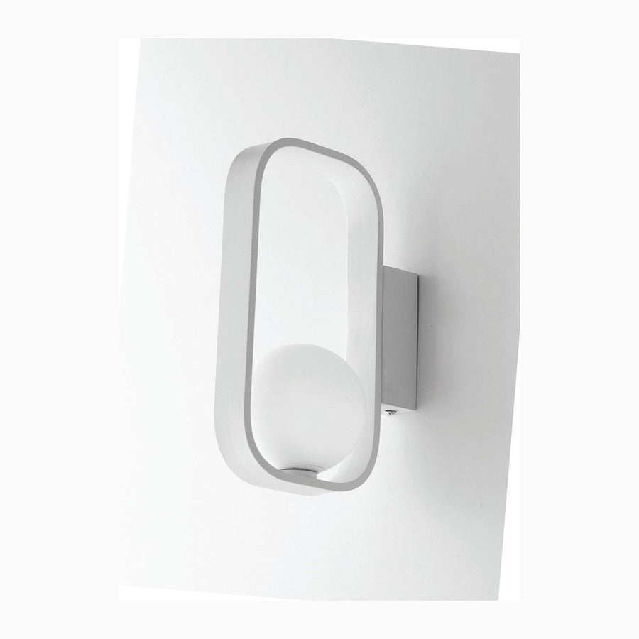 Applique murale blanche vue de face sur fond neutre, cadre ovale et diffuseur rond.