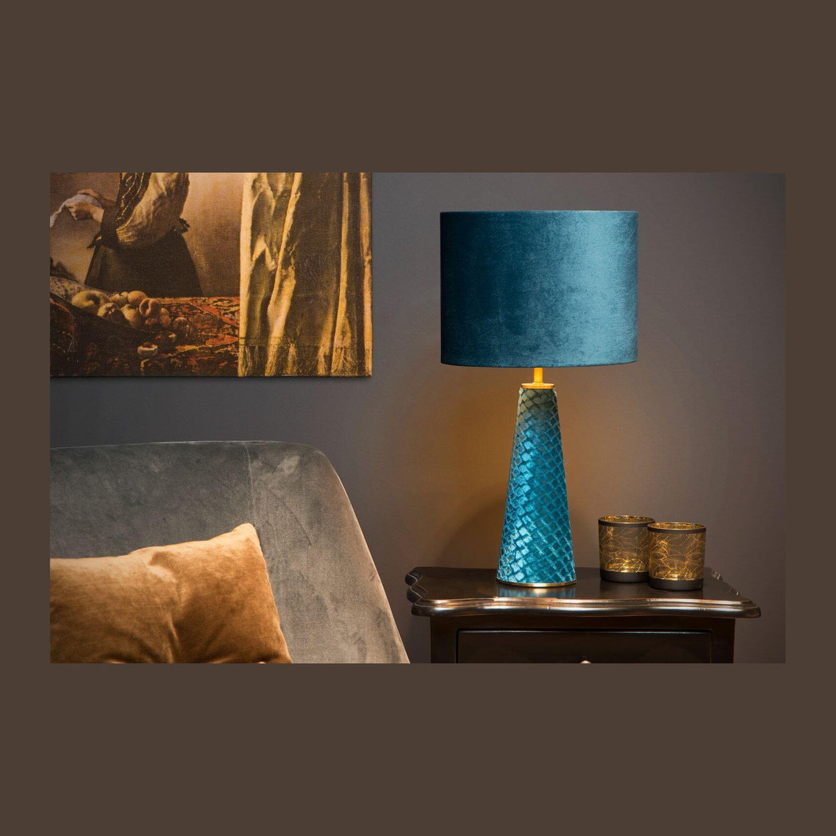 Mise en ambiance chaleureuse, lampe posée sur une table de nuit près d'un fauteuil