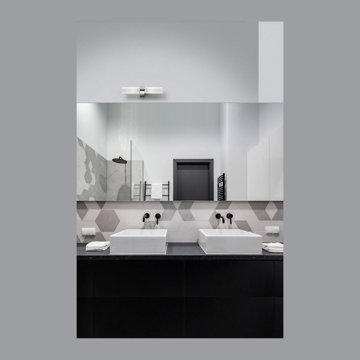 Applique murale à deux tubes de verre opalin fixée au-dessus du miroir d'une salle de bain