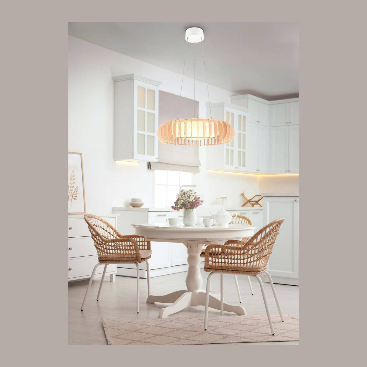 Suspension blanche allumée au-dessus d'une table ronde dans une cuisine blanche.