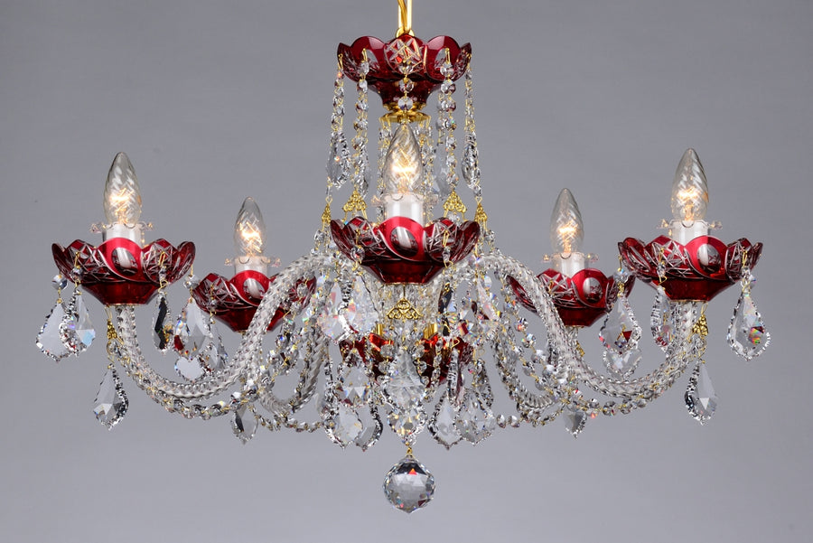 Lustre en cristal à cinq bras rouges, gouttes taillées et ampoules allumées, vue de face.