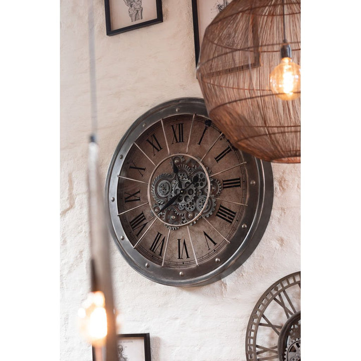 Horloge en chiffres romains, mécanisme visible, métal + verre, gris antique. | Designix -     - https://designix.fr