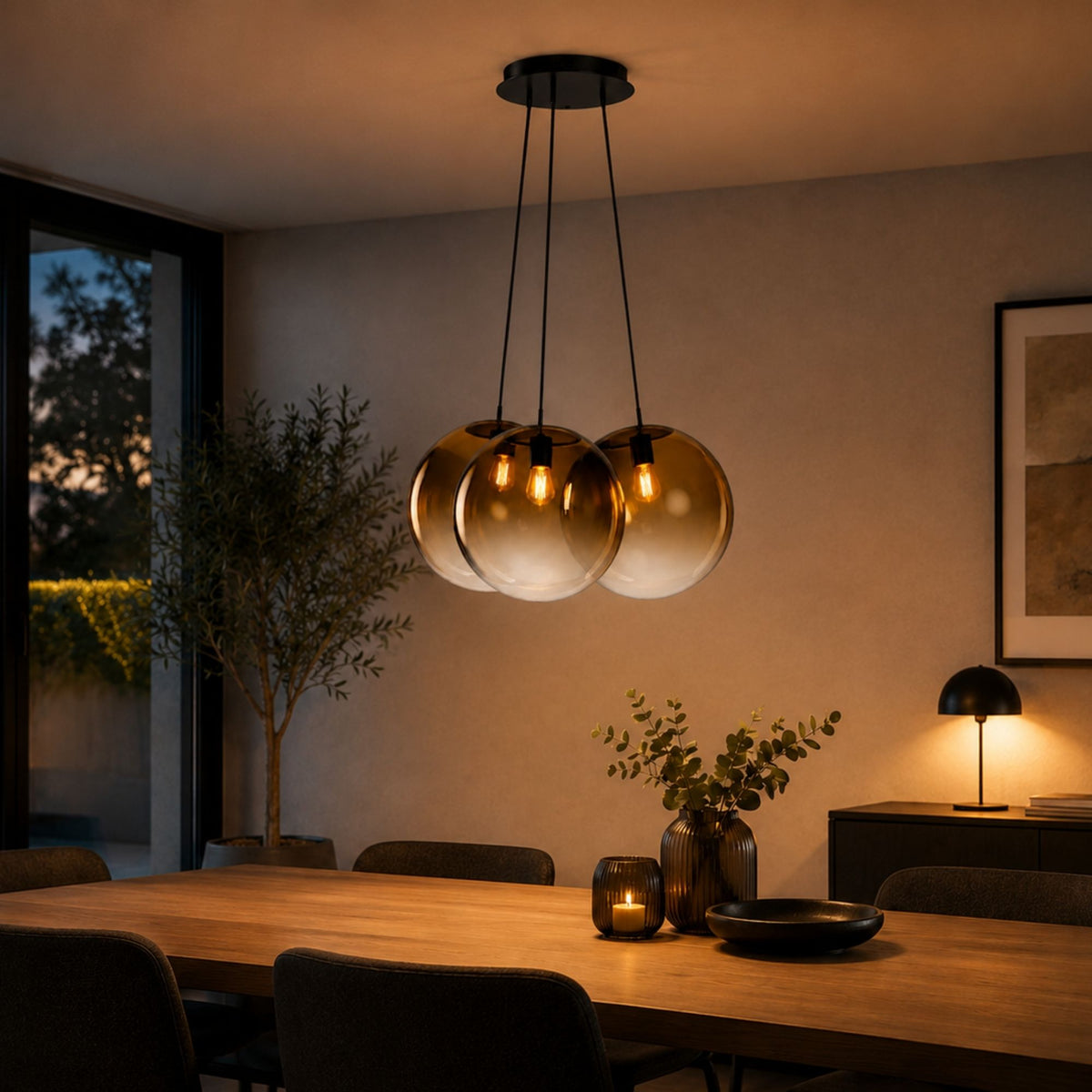 Suspension trois globes ambrés allumée au-dessus d'une table à manger en bois