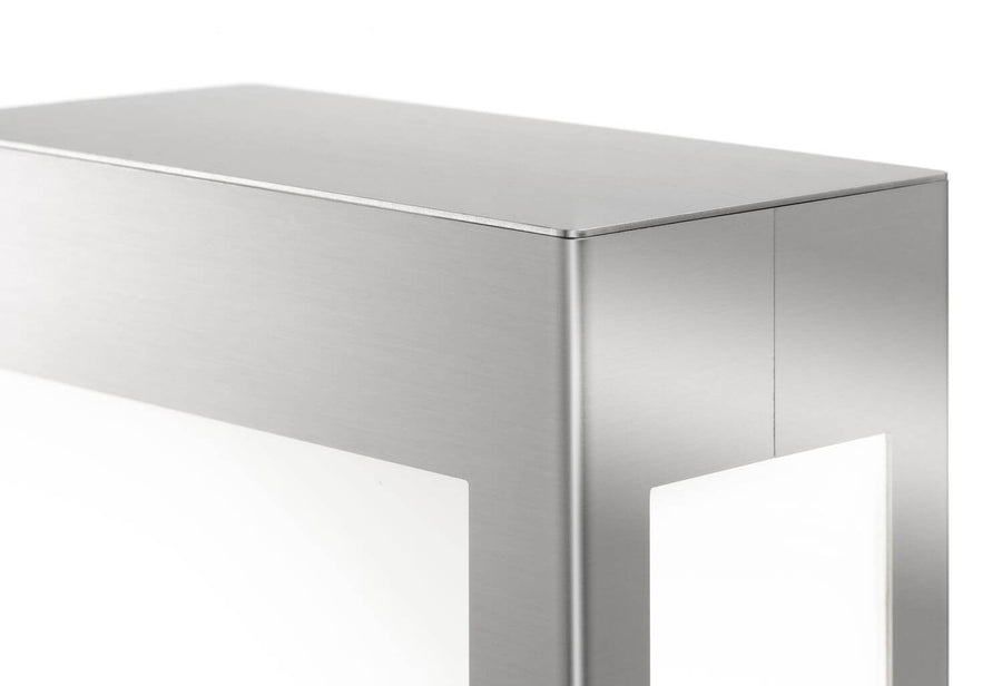 Détail du coin supérieur en inox brossé et de la fenêtre lumineuse blanche.