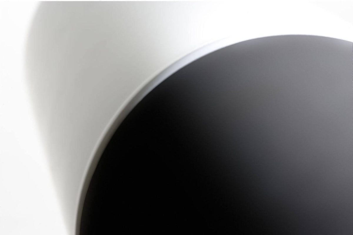 Gros plan sur la transition entre le corps anthracite et le diffuseur blanc du luminaire.