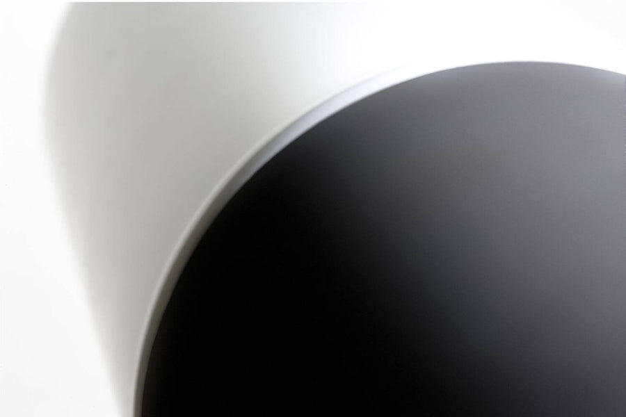 Gros plan sur la transition entre le corps anthracite et le diffuseur blanc du luminaire.