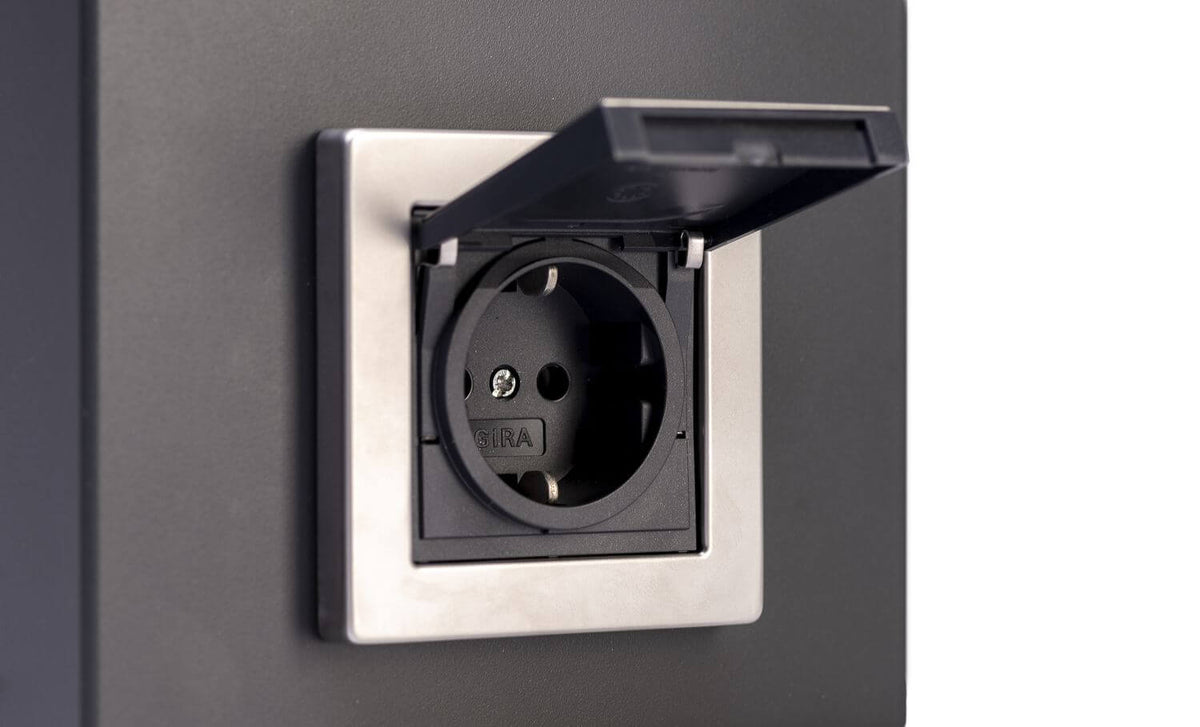 Détail de la prise électrique protégée par clapet, intégrée dans la borne anthracite.