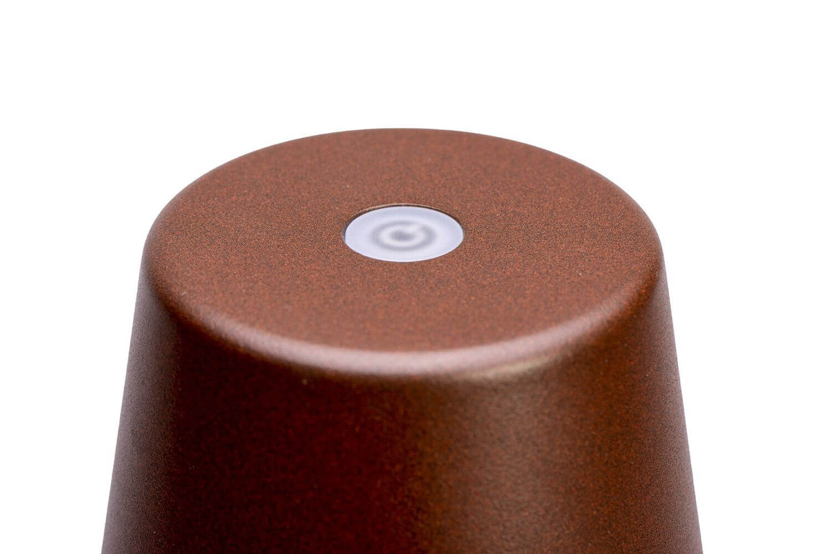 Gros plan du bouton tactile placé au sommet de l'abat-jour, texture mate rouille