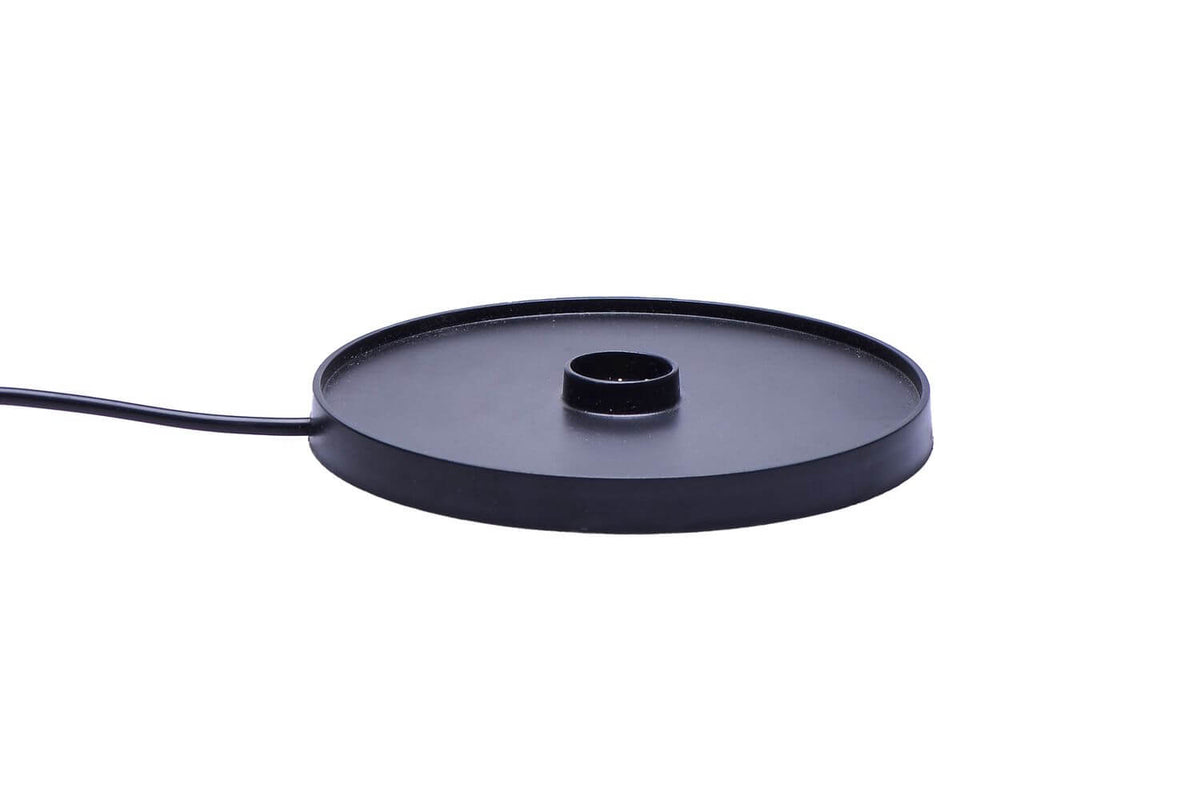 Détail de la base de charge noire ronde et de son câble d'alimentation