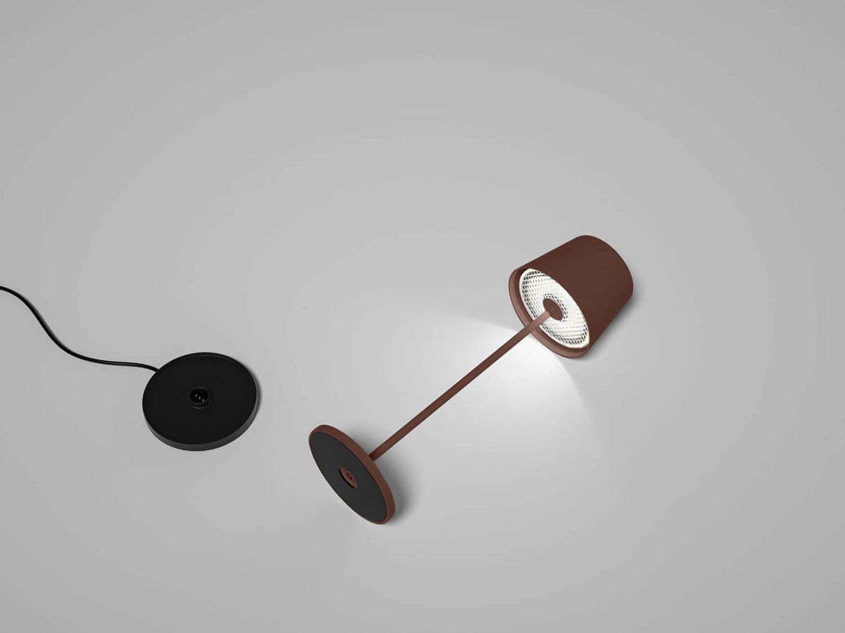 Mise en ambiance : lampe inclinée allumée, détachée de sa base de charge