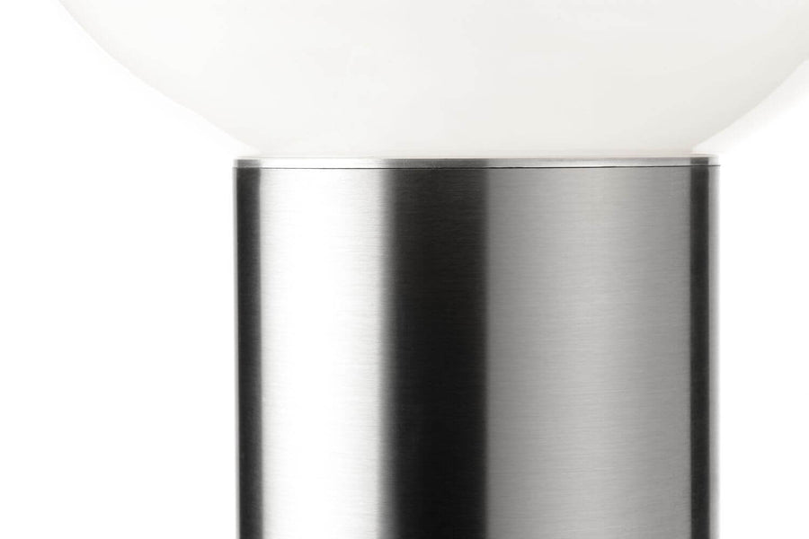 Gros plan sur la finition brossée du fût cylindrique en acier inoxydable.