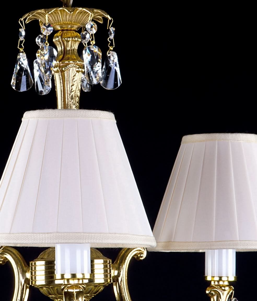 Détail du sommet du lustre en laiton orné de cristaux taillés et de sa chaîne.