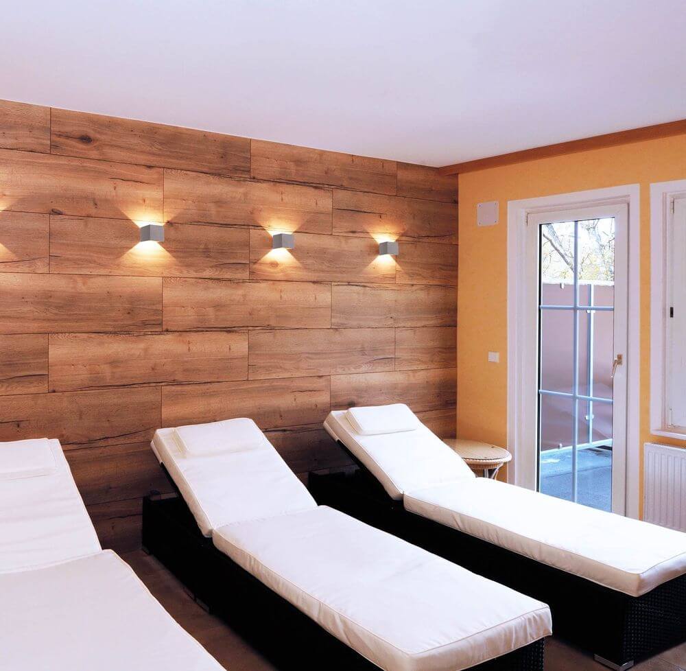 Trois appliques cubes en béton éclairent un mur bois de spa