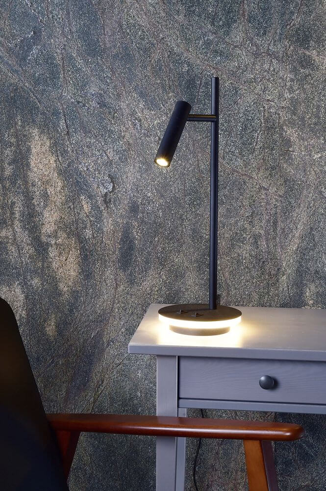 Détail de la lampe posée sur une console grise, halo lumineux sous le socle