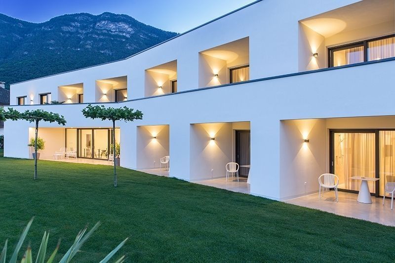 Mise en ambiance nocturne sur la façade blanche d'une maison moderne.
