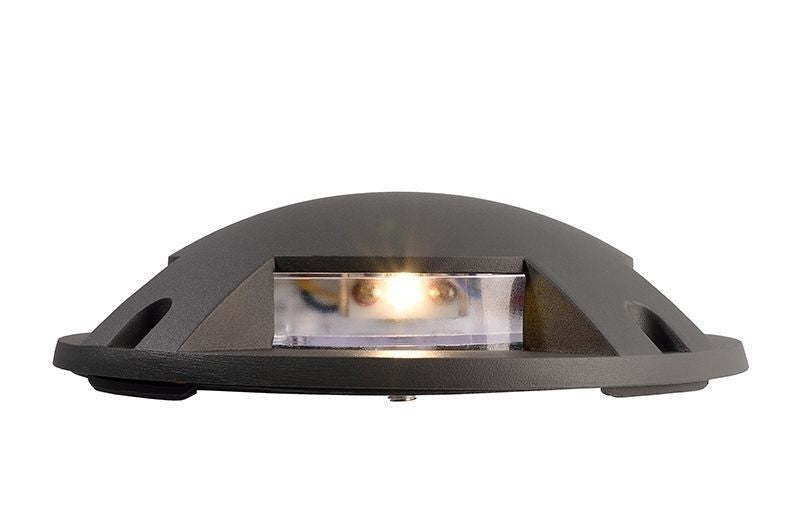 Profil latéral du luminaire allumé, dévoilant la lentille transparente et la lumière chaude.