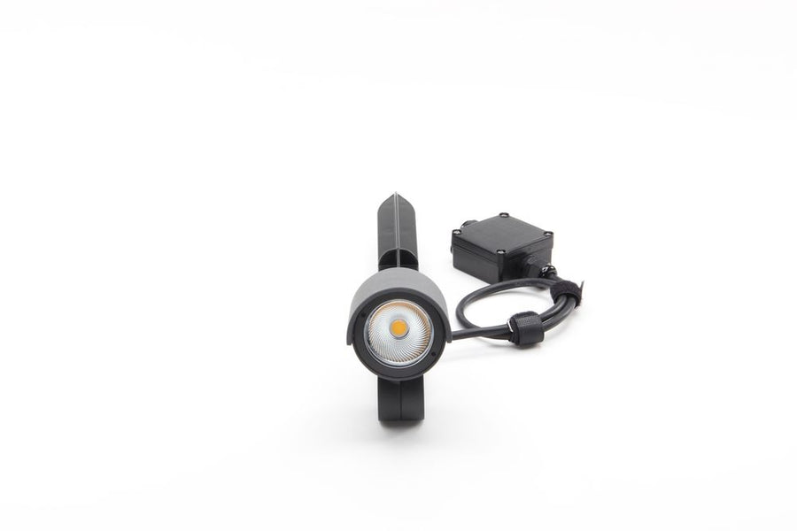 Vue de face du projecteur cylindrique allumé, lentille LED et boîtier de raccordement